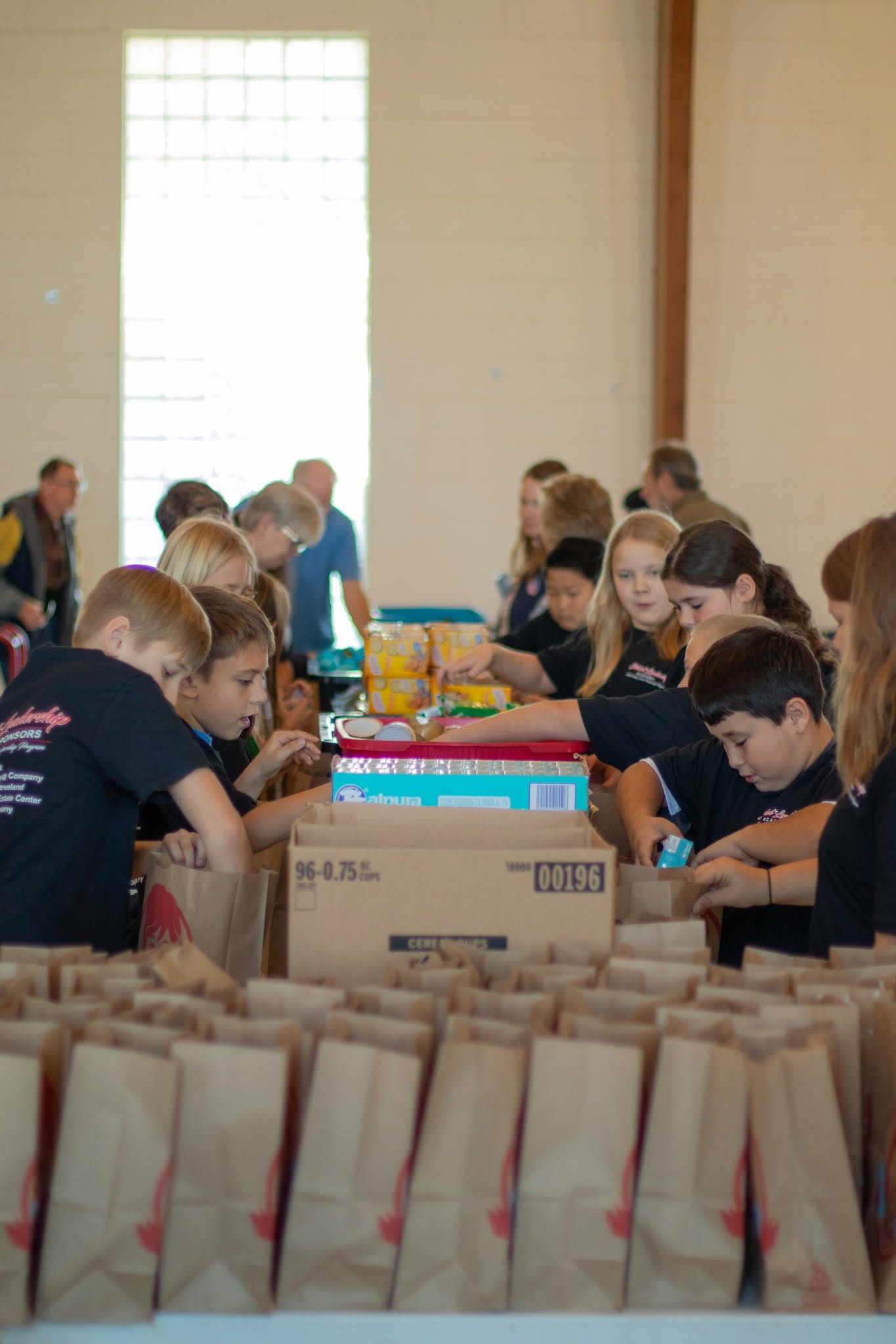 RUMC volunteers and children preparing community snack packs